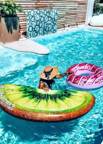 Persona in piscina con gonfiabili a forma di kiwi e ciambella.