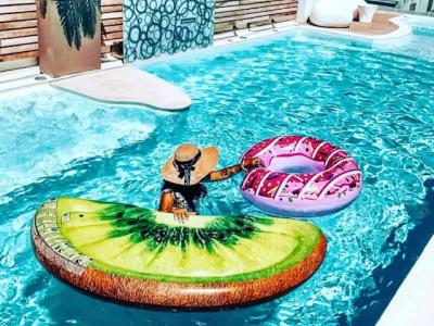 Persona in piscina con gonfiabili a forma di kiwi e ciambella.