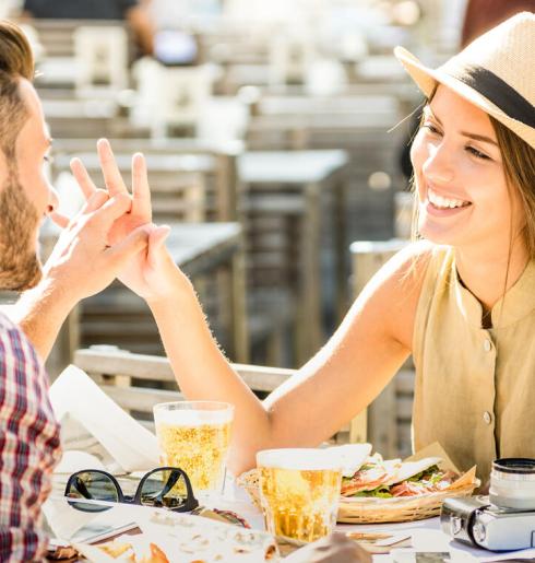 Happy couple at restaurant with food and drinks.