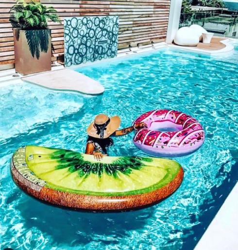 Persona in piscina con gonfiabili a forma di kiwi e ciambella.