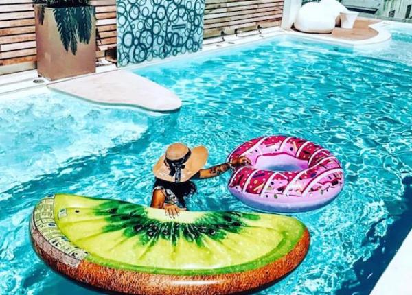 Persona in piscina con gonfiabili a forma di kiwi e ciambella.